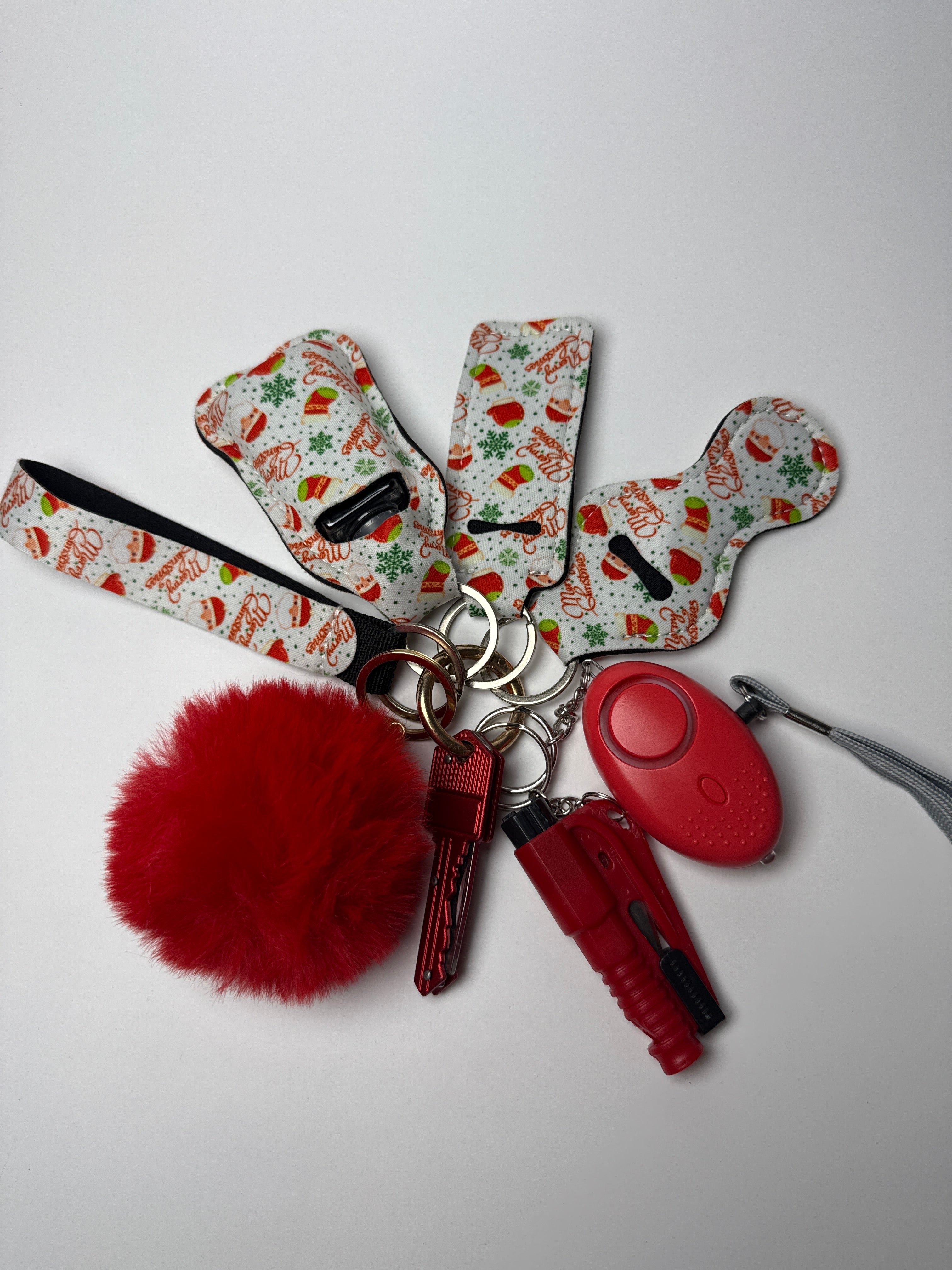 Holiday snack print wristlet keychain set with red pom charm, compact personal alarm, and mini light on a white background.