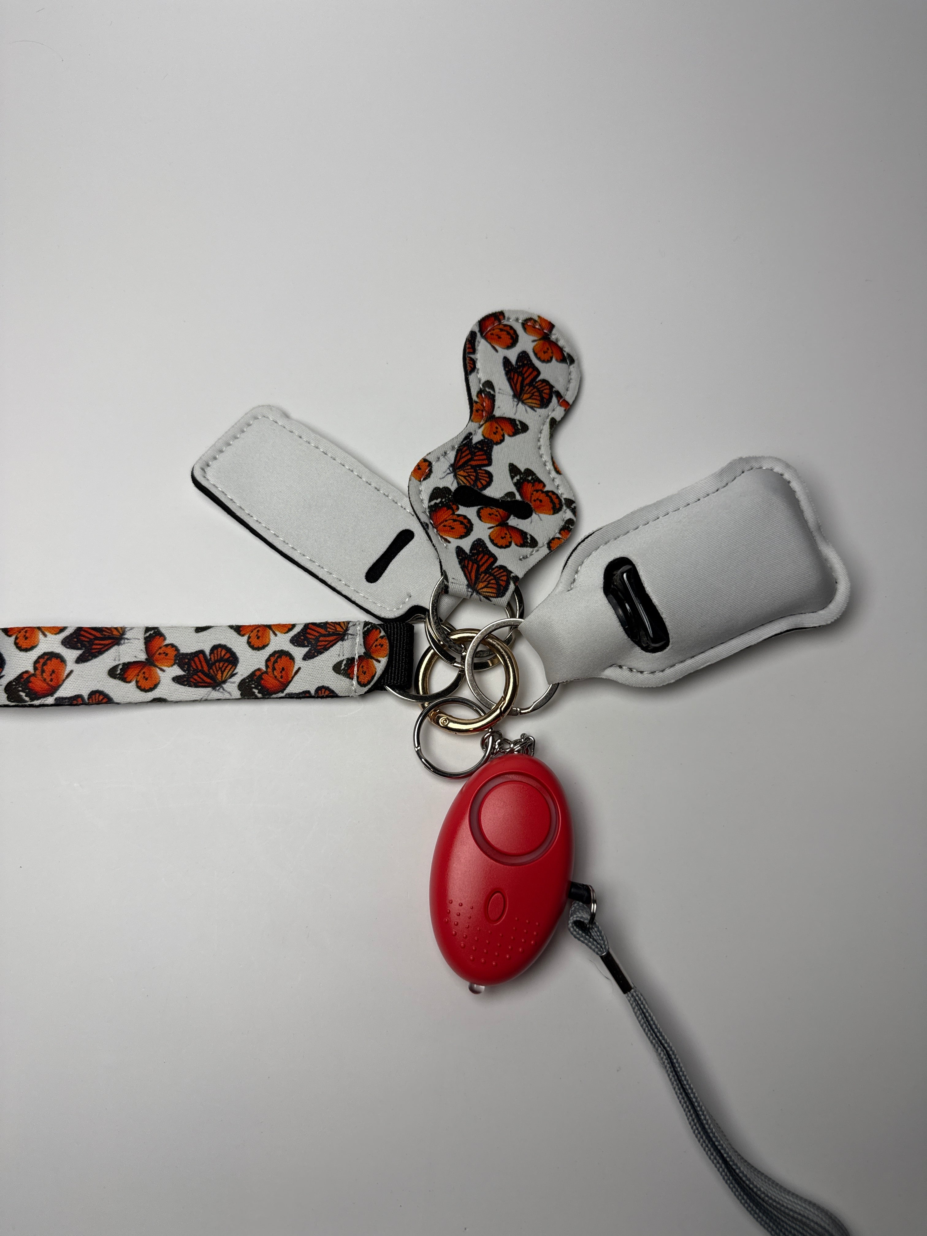 Butterfly print wristlet keychain set with compact personal alarm on a white background.